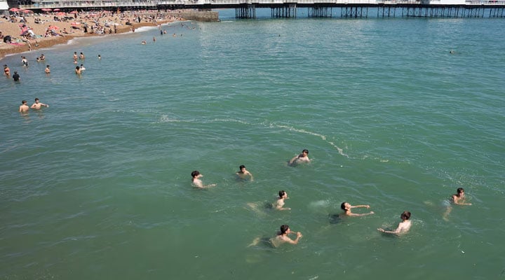 Beachgoers swim in the sea during warm weather as temperatures rise across the UK, in Brighton, Britain, June 30, 2025. — Reuters