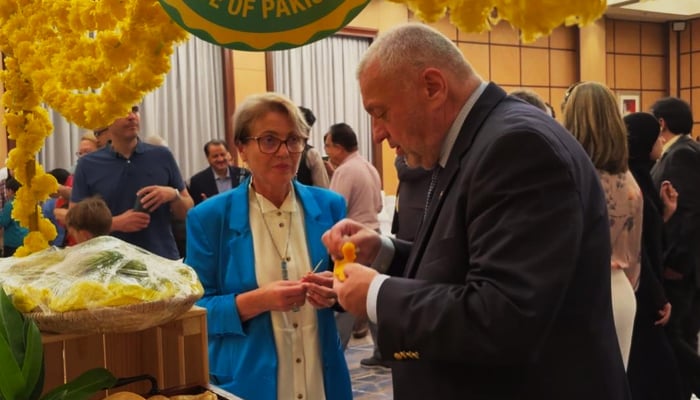 Diplomat samples a slice of mangoes at the Pakistani Mango Festival. — Reporter