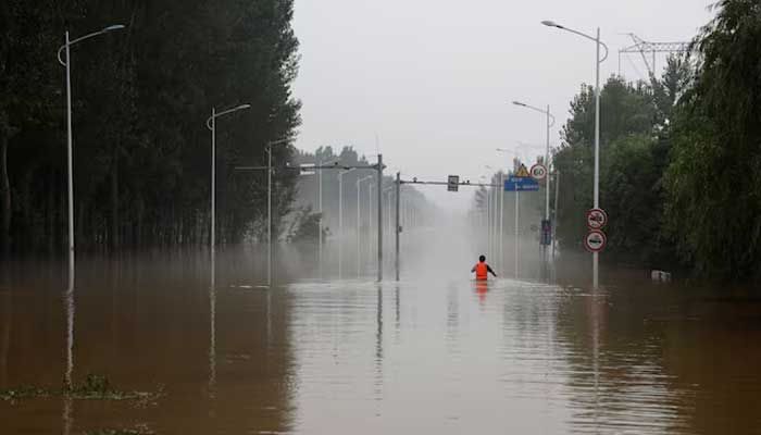 A man makes his way through a flooded road after the rains and floods brought by remnants of Typhoon Doksuri, in Zhuozhou, Hebei province, China August 3, 2023. — Reuters/File