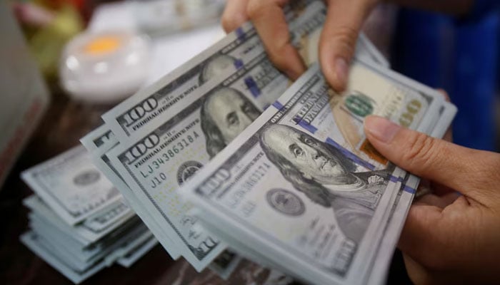 An employee of a bank counts US dollar notes. — Reuters