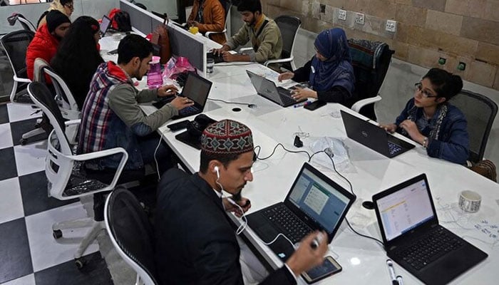 Employees seen working at a call centre in Lahore. — AFP/File