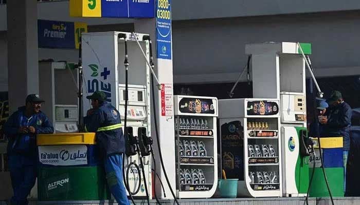Employees at a fuel station wait for customers in Islamabad. — AFP/File