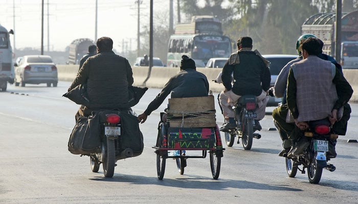 A person hold a motorcycle on the way at Karnal Sher Khan Shaheed Road in Islamabad on January 30, 2025. — Online