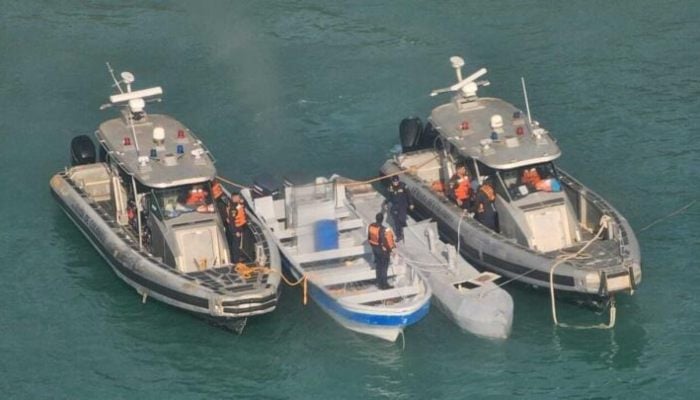 An unmanned semi-submersible, known as a Low Profile Vessel, between two Colombian Navy vessels, July 2, 2025. — AFP