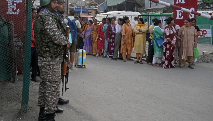 Indian security personnel stand guard as Hindu pilgrims await their registration ahead of the the annual Amarnath pilgrimage. — AFP