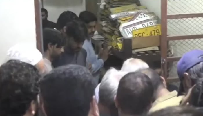 People lined up at Karachis Civic Centre to get their new number plates. — Geo News