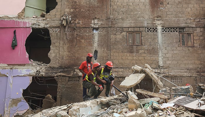 Rescue workers use a search cam to look for survivors as they go through the rubble of a five-storey residential building, which collapsed in Karachi, on July 4, 2025. — Reuters