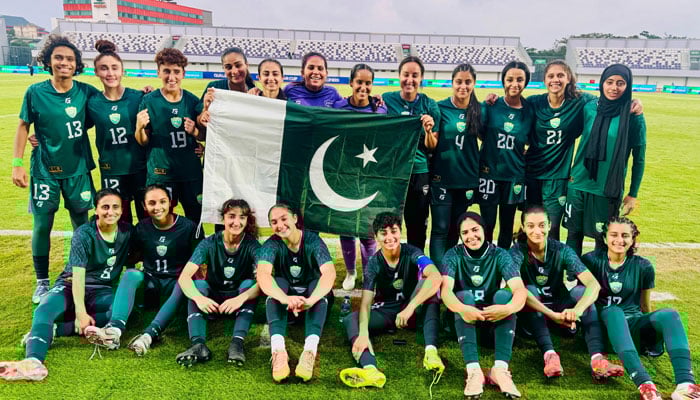 Pakistans national womens  football team poses with the national flag in this undated image. — Reporter