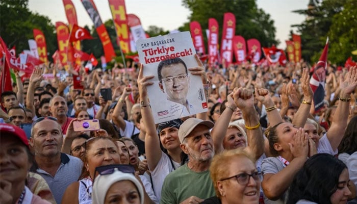 A protester holds a poster of Istanbuls detained Mayor Ekrem Imamoglu as they listen to the leader of Turkeys main opposition Republican Peoples Party (CHP) Ozgur Ozel (not pictured) during a rally protesting the 100th day of his detention at Sarachane Square in Istanbul on 1 July 2025. — AFP