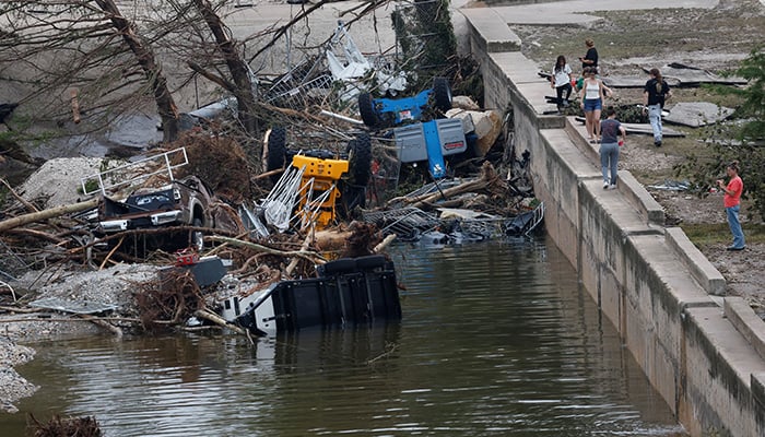 People stand near debris following flash flooding, in Kerrville, Texas, U.S. July 5, 2025. — Reuters