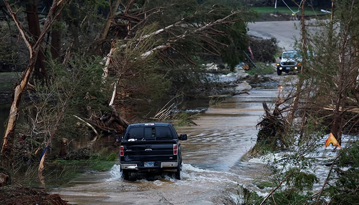 A vehicle rides through a flooded road, following flash flooding, in Hunt, Texas, US July 6, 2025. — Reuters