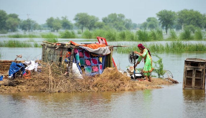 A woman taking refuge is seen with her belongings, following rains and floods during the monsoon season in Sohbatpur, August 29, 2022. — Reuters