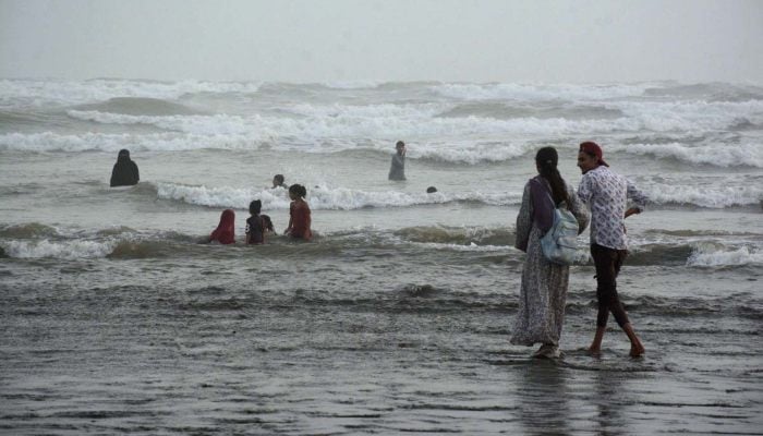 A family bathes and plays in the ocean waves at Sea View beach to find relief from the scorching heat in Karachi, June 16, 2025. — APP