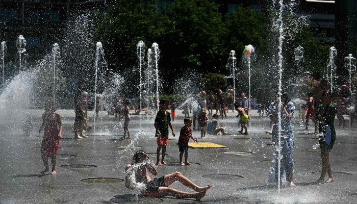 Children and adults cool off and enjoy water games at a water fountain in the Andre-Citroen public park as a heatwave hits southern Europe, in Paris, France, on June 29, 2025. — AFP