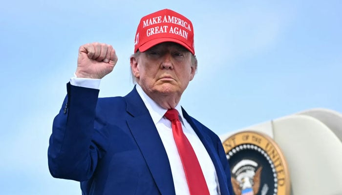 President Donald Trump pumps his fist as he boards Air Force One in Morristown, New Jersey, on June 21. — AFP