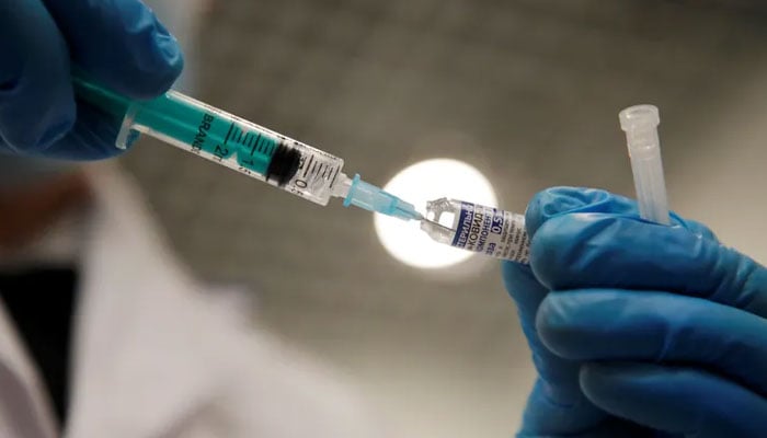 A representational image showing a person using a syringe to extract vaccine from a vile. — Reuters/File