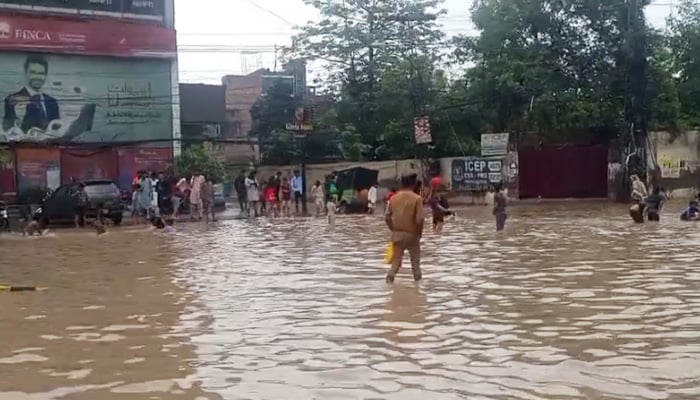 Residents wade through a waterlogged street in Lahore on Thursday, July 10, 2025, after heavy monsoon rains brought the city to a standstill. — Geo News