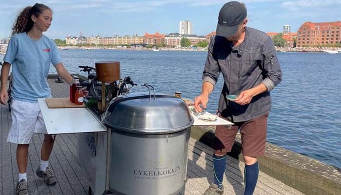 Danish chef Morten Kryger Wulff cooks on his self-designed kitchen-bike during a stop of a gastronomical bike tour on July 2, 2025 in Copenhagen, Denmark. — AFP
