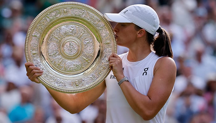 Polands Iga Swiatek poses with the trophy after winning the womens singles final of Wimbledon against Amanda Anisimova of the US, All England Lawn Tennis and Croquet Club, London, Britain - July 12, 2025. — Reuters