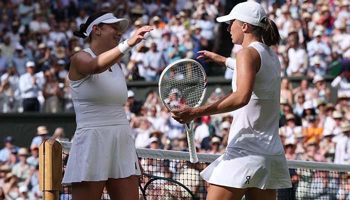 Polands Iga Swiatek with Amanda Anisimova of the US after winning the womens singles final at Wimbledon. — Reuters