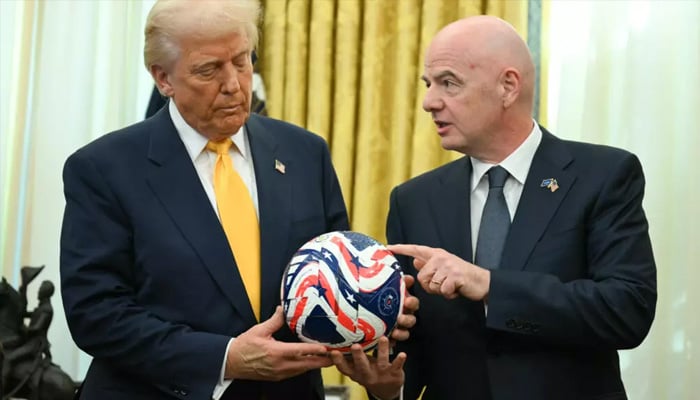 US President Donald Trump examines a football as FIFA president Gianni Infantino speaks in this undated image. — AFP