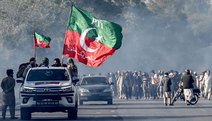 PTI supporters march towards Islamabad after clearing shipping containers placed by authorities during a demonstration demanding Imran Khans release, in Punjabs Hasan Abdal on November 25, 2024. — AFP