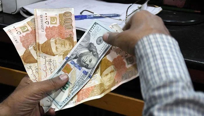 A foreign currency changer counts Pakistani rupee notes at a shop in Karachi, on March 2, 2023. — Online