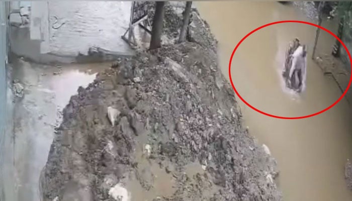 Motorcyclist falls into rainwater-filled uncovered pit in Lahore, July 16, 2025. — Screengrab/Geo News