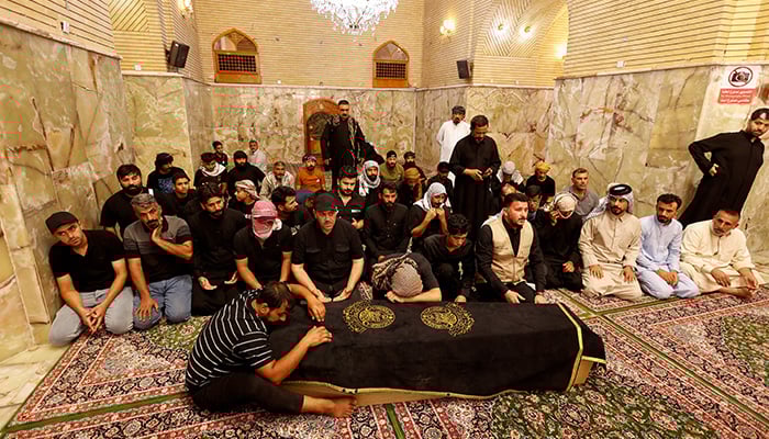 Mourners attend the funeral of victims who died in an overnight fire at a major shopping center in al-Kut, in Najaf, Iraq, July 17, 2025. — Reuters
