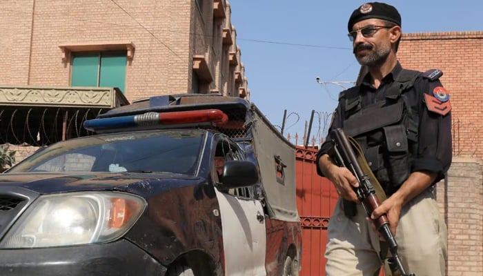 A Balochistan Police officer stands guard near his vehicle. — Reuters