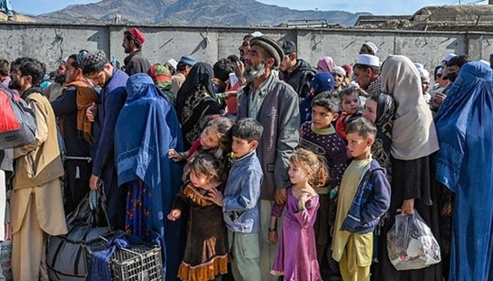 Afghan refugees wait in a queue to cross the Pakistan-Afghanistan border in Torkham on October 27, 2023. — AFP
