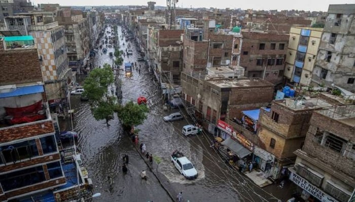 Commuters make their way through a flooded street during heavy monsoon rains in Hyderabad, in Sindh province, on July 14, 2025. — AFP