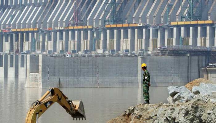 A worker stands in front of the main dam of the Three Gorges Dam Project on the Yangtze River in Yichang, Chinas Hubei province, August 29, 2002. — Reuters