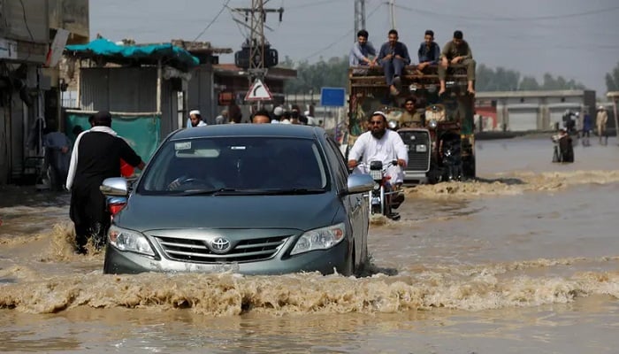 Vehicles move amid flood water along a road, following rains and floods during the monsoon season in Nowshera. —Reuters/File