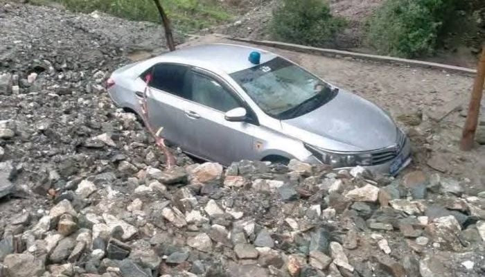 A car caught in a landslide on Babusar Chilas road. — Reporter