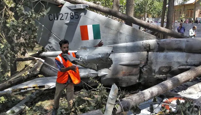 A civil defence team member removes the wreckage of a MiG-21 Bison aircraft of the Indian Air Force (IAF) after it crashed in Soibugh in Budgam district of IIOJK, August 24, 2015. — Reuters