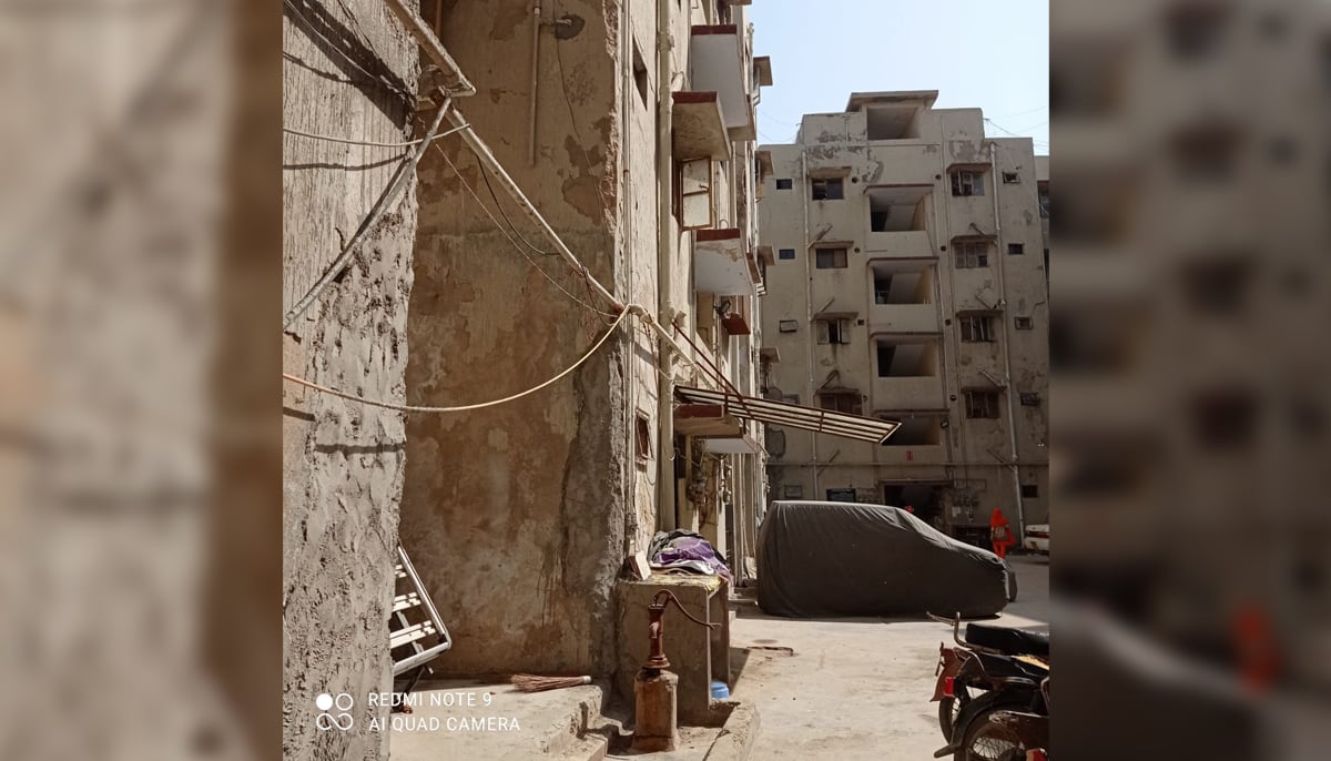 An image of a demolished building Jan Plaza showing the crumbling concrete and a hand-pump. — Photo by author