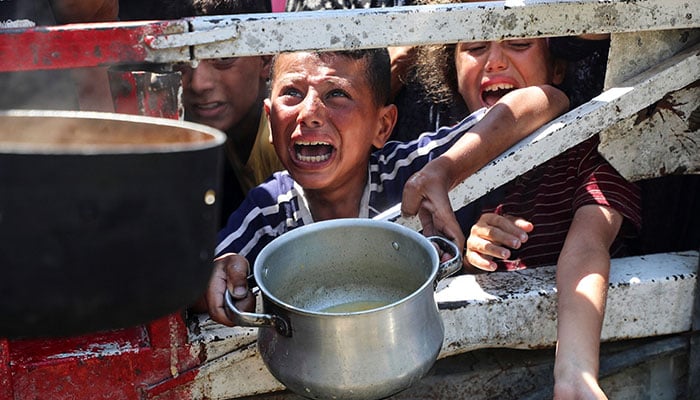 Palestinians wait to receive food from a charity kitchen, amid a hunger crisis, in Gaza City on July 23, 2025. — Reuters