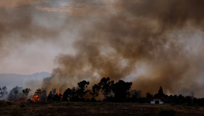 A wildfire burns next to a house on the outskirts of Valmojado, Spain, July 17, 2025. — Reuters