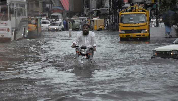 A man rides on a motorcycle amid flood waters along a road during the monsoon season in Rawalpindi, Pakistan July 19, 2023 — Reuters