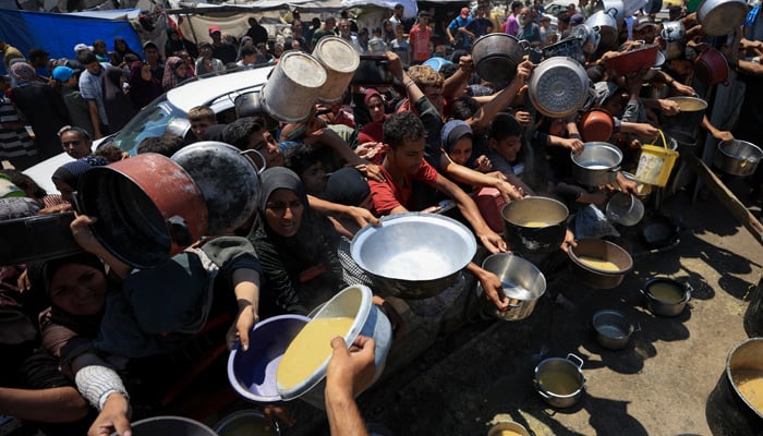 Palestinians gather to receive food from a charity kitchen, amid a hunger crisis, in Gaza City, July 25, 2025. — Reuters