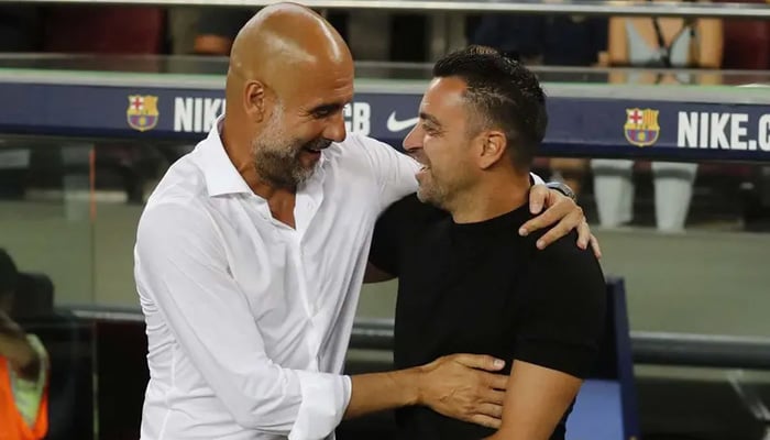 (From left) Spanish coaches Pep Guardiola and Xavi Hernandez hug during a match in this undated image. — Reuters/File