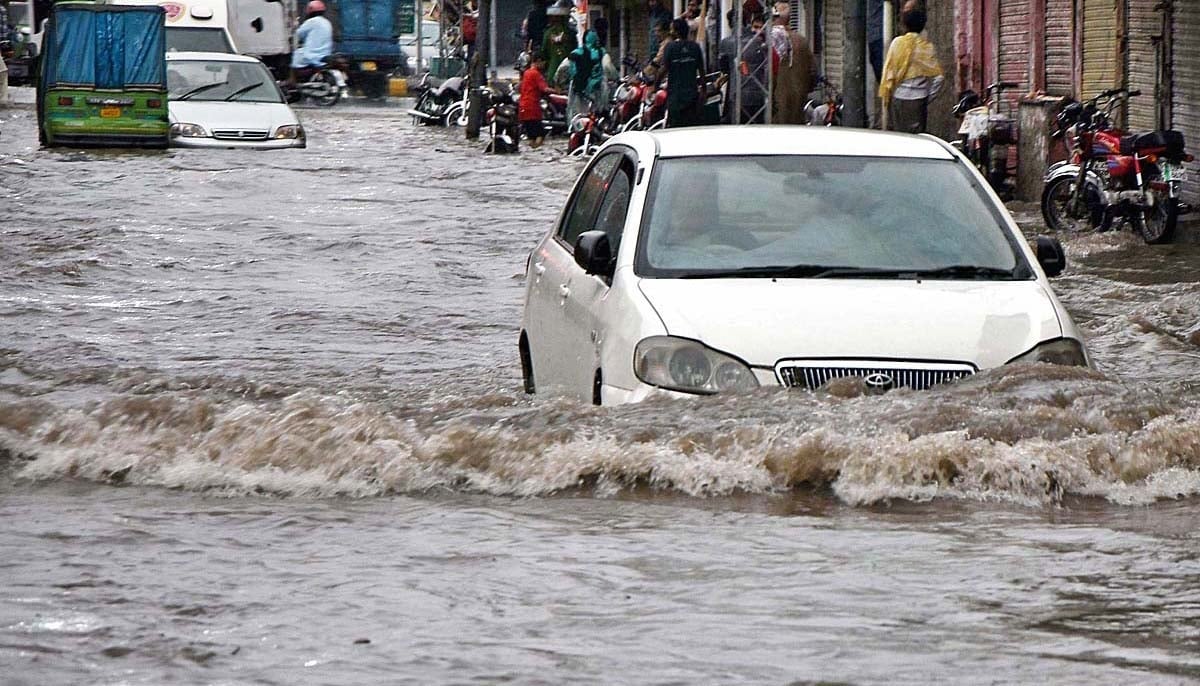 Vehicles passing through the rainwater accumulated at Garri Shahu after heavy rain in Lahore. —APP/File