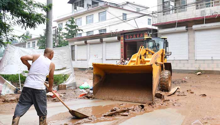 Villagers clear the mud from a street after heavy rainfall flooded Yi county of Baoding, Hebei province, China July 26, 2025. — Reuters