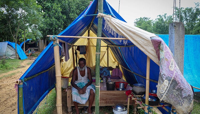 A man sits inside a tarpaulin tent inside a makeshift shelter camp in Goalpara district in the northeastern state of Assam, India on July 18, 2025. — Reuters