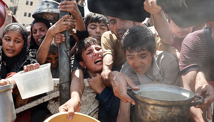 Palestinians wait to receive food from a charity kitchen, amid a hunger crisis, in Gaza City, July 28, 2025. — Reuters