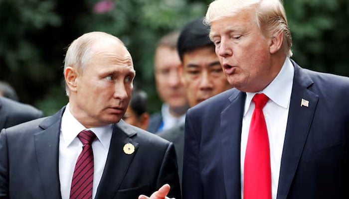 US President Donald Trump and Russias President Vladimir Putin talk during the family photo session at the APEC Summit in Danang, Vietnam November 11, 2017. — Reuters