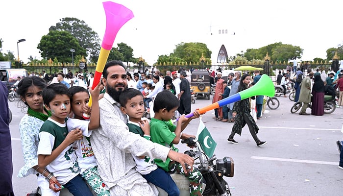 A family celebrates Independence Day of Pakistan near the Mazar-e-Quaid in Karachi, on August 14, 2024. — APP