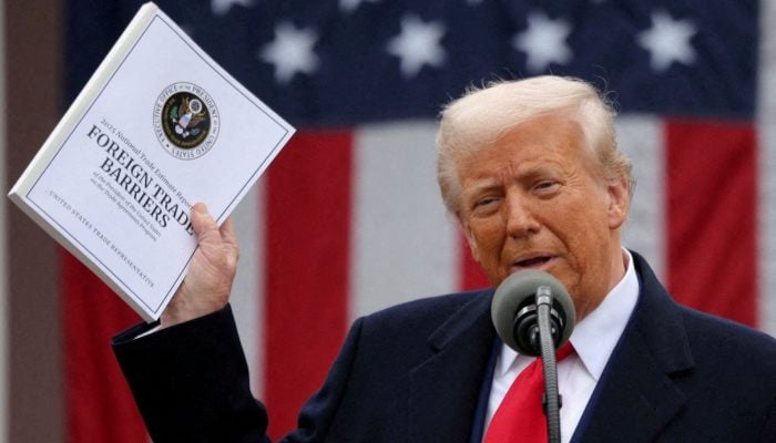 US President Donald Trump holds a Foreign Trade Barriers document as he delivers remarks on tariffs in the Rose Garden at the White House, Washington, US, April 2, 2025. — Reuters
