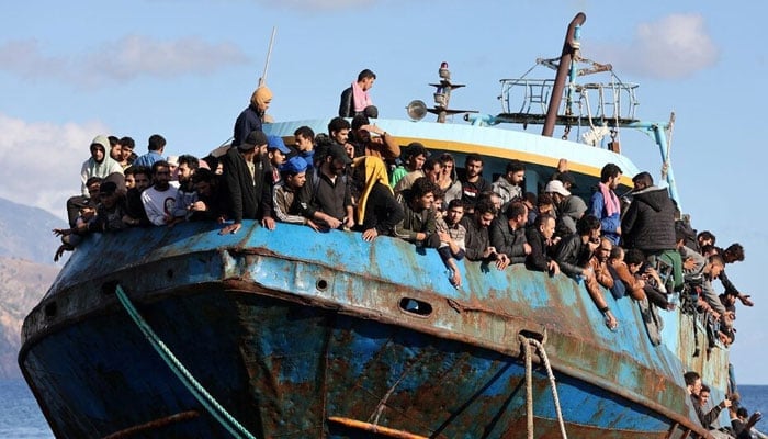 Migrants sit onboard a fishing boat at the port of Paleochora, following a rescue operation off the island of Crete, Greece. — Reuters/File